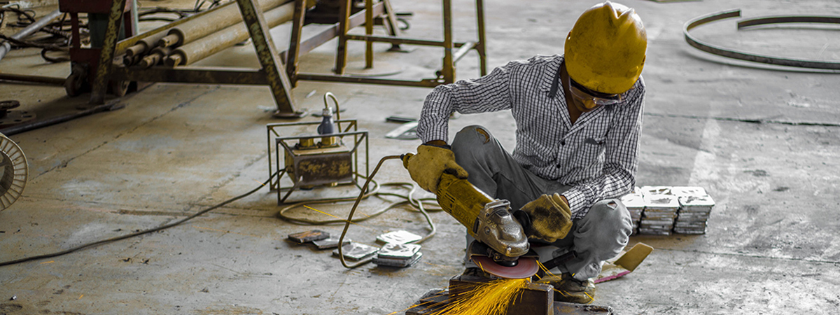 A construction worker using a grinder on the floor