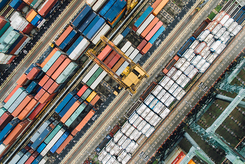 Aerial view of multiple shipping containers and a boat